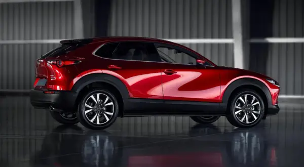 Błyszczący czerwony Mazda CX-30 z profilu. Poznaj jego kompaktowe mazda cx 30 wymiary, idealne do miasta.