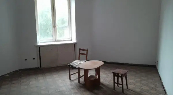 Puste mieszkania za odstępne w Łodzi. Stół, krzesło i stołek czekają na lokatorów.