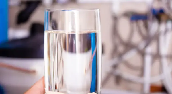 Verre d'eau pure, prêt à boire, issu d'un adoucisseur d'eau, pour une hydratation saine selon l'OMS.