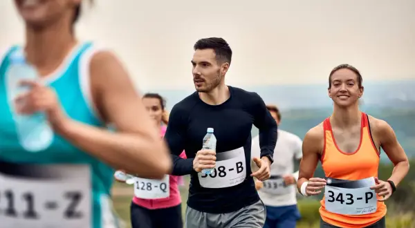 Uczestnicy biegną w półmaratonie, każdy pokonuje kolejne kilometry.