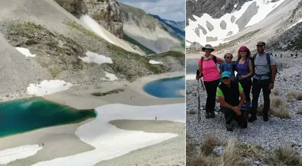 Gruppo di escursionisti al lago di Pilato, con le sue acque turchesi e i nevai circostanti.