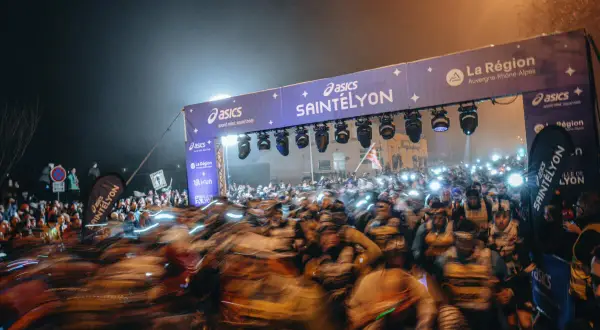 Foule de coureurs au départ de la SaintéLyon, sous un portique illuminé. Les résultats de cette course nocturne promettent d'être intenses.