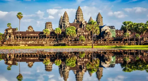 Piękna kambodża pogoda nad Angkor Wat. Lotosowy staw odbija majestatyczne wieże świątyni w błękitnym niebie z chmurami.