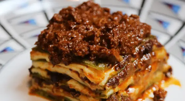 Una porzione di lasagne al ragù, stratificata con pasta, besciamella e un ricco ragù di carne.