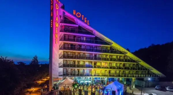 Hotel Diament Ustroń nocą, z neonami "SPA" i "HOTEL". Wiele pozytywnych **spa & wellness hotel diament ustroń opinie** potwierdza jego wyjątkowość.