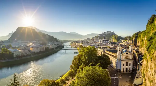 Sonnenaufgang über Salzburg. Die Salzach fließt durch die Stadt, im Hintergrund die Festung Hohensalzburg. Ein perfekter Morgen für smbs salzburg.