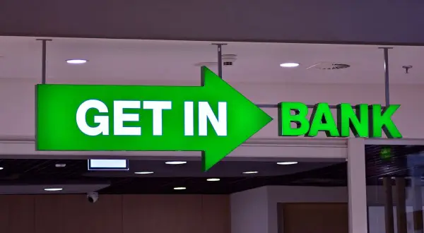 Zielona, podświetlana strzałka z napisem "GET IN" prowadzi do wejścia do banku.