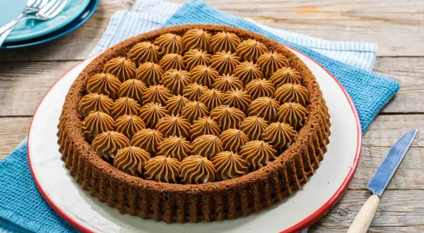 Una deliziosa crostata mascarpone e nutella, con una base scura e un ripieno cremoso a forma di stelle.