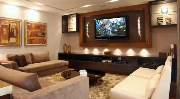 Accogliente soggiorno con divani, TV e quadri. Soluzioni d'arredo per una stanza senza finestra, creando un'atmosfera luminosa e moderna.