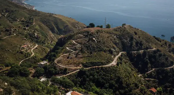 Serpentinenstraßen schlängeln sich durch die Hügel bei Taormina. Entdecken Sie versteckte Orte und genießen Sie die Aussicht auf das Meer – Taormina Geheimtipps für Abenteurer.