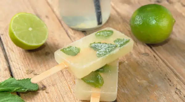 Erfrischendes Mojito Eis mit Minze und Limette auf Holz. Perfekt für heiße Tage!