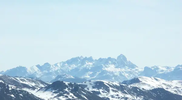 Picos nevados de Europa bajo un cielo azul claro.