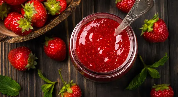 Frische Erdbeeren und ein Glas selbstgemachte Erdbeermarmelade. Ein einfaches Erdbeermarmelade Rezept für den Sommer.