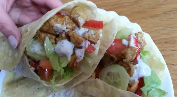 Dwie porcje pysznego, domowego kebab w tortilli z kurczakiem, warzywami i sosem. Idealne na szybki lunch.