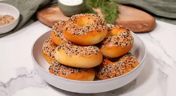 Ein Haufen frisch gebackener Bagels, bestreut mit Sesam und Mohn, perfekt für ein proteinreiches Bagel-Rezept.