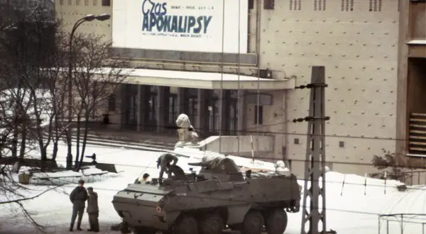 Wóz bojowy na śniegu, ludzie w mundurach, budynek z napisem "Czas Apokalipsy". Atmosfera przypomina stan wojenny.