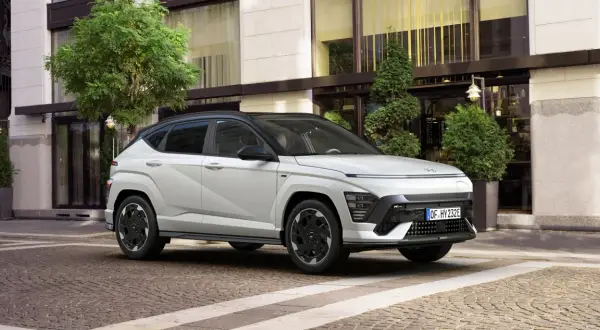 Biały Hyundai Kona N Line na tle eleganckiego budynku. Sprawdź aktualną hyundai kona cena i wybierz swój wymarzony model.
