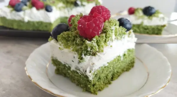 Pyszne ciasto leśny mech z mascarpone, udekorowane malinami i borówkami, wygląda jak leśna polana.
