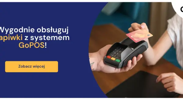 Dłoń zbliża kartę zbliżeniową do terminala płatniczego.