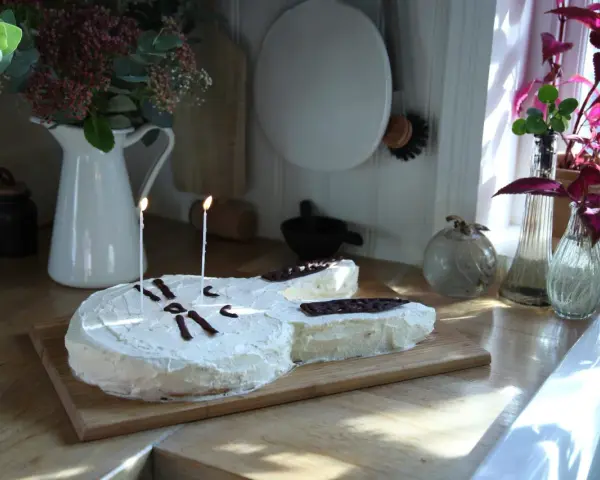 En gitarrformad tårta med vit frosting och chokladdekorationer, perfekt för alla musikälskare. En av många tårt ideer för en speciell dag.