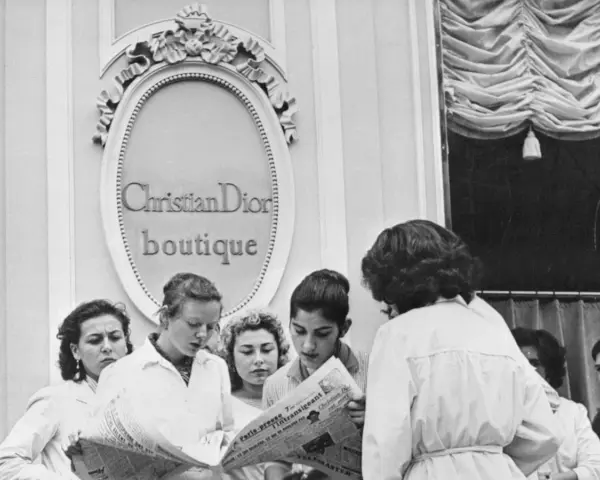 Donne leggono un giornale davanti alla boutique Christian Dior, dove nasce la moda.