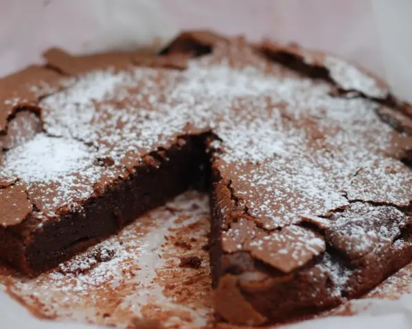 En saftig kladdkaka, pudrad med florsocker, redo att avnjutas. Perfekt för fikat eller som en del av ett dessertbord med andra kladdkaka kakor.
