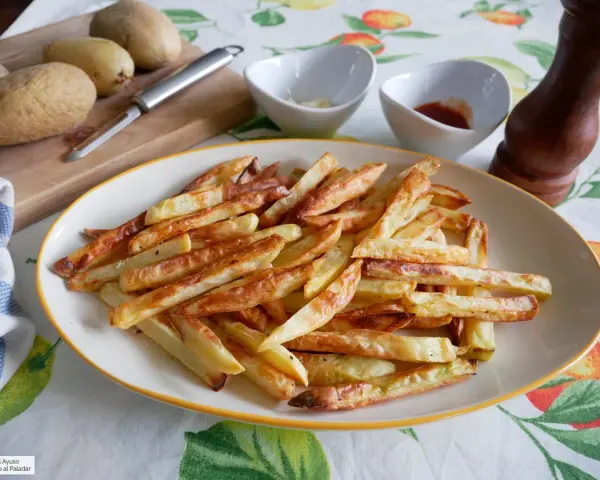 Patatas fritas doradas y crujientes, recién salidas de la freidora de aire. Perfectas para acompañar cualquier comida.