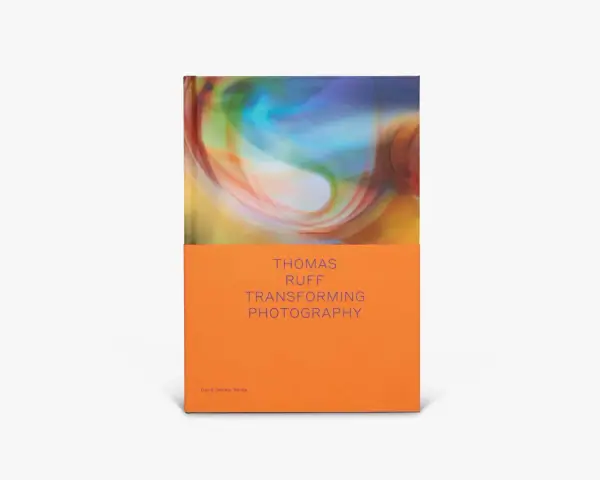 Okładka książki "Thomas Ruff: Transforming Photography" z abstrakcyjnym, kolorowym wzorem i pomarańczowym spodem.