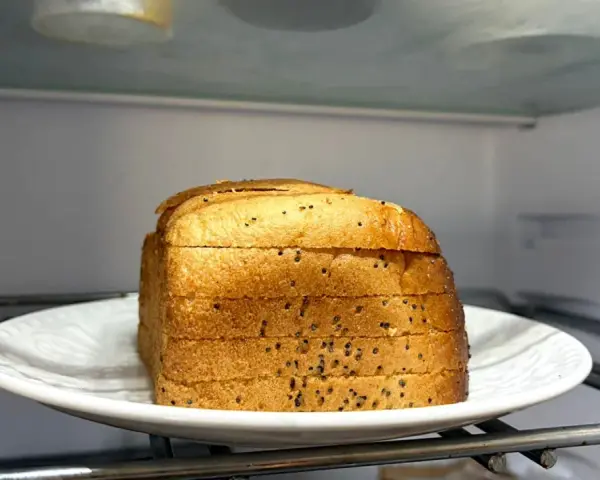 Kromki chleba na talerzu w lodówce. Czy można trzymać chleb w lodówce? To pytanie nurtuje wielu.