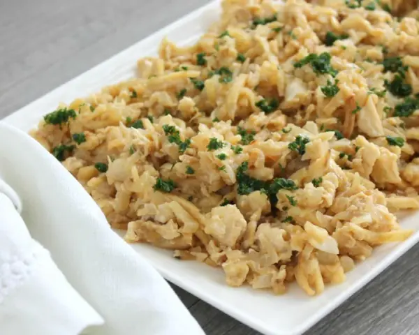 Delicioso plato de migas de bacalao desmenuzado, salteado y espolvoreado con perejil fresco.