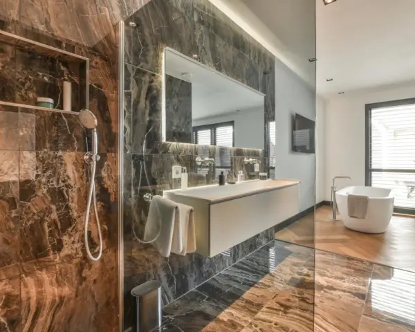 Bagno moderno con doccia, vasca e lavabo sospeso. La rubinetteria Bossini, con il suo design elegante, completa l'arredo di lusso.