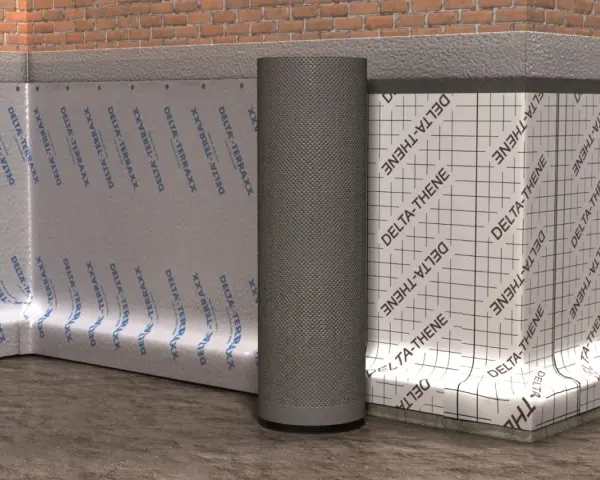 Eine Noppenbahn schützt die Wand vor Feuchtigkeit. Sie ist an der Ziegelwand befestigt, daneben eine weiße Bahn mit Gitternetz.