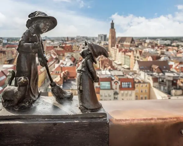 Dwa krasnale i kot na tle Wrocławia. Zastanawiasz się, ile jest krasnali we Wrocławiu?