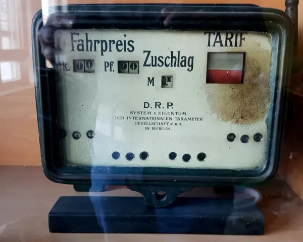 Altes Taxameter mit "Fahrpreis" und "Zuschlag" Anzeige. Der Tarif ist auf 0,90 Mark eingestellt.