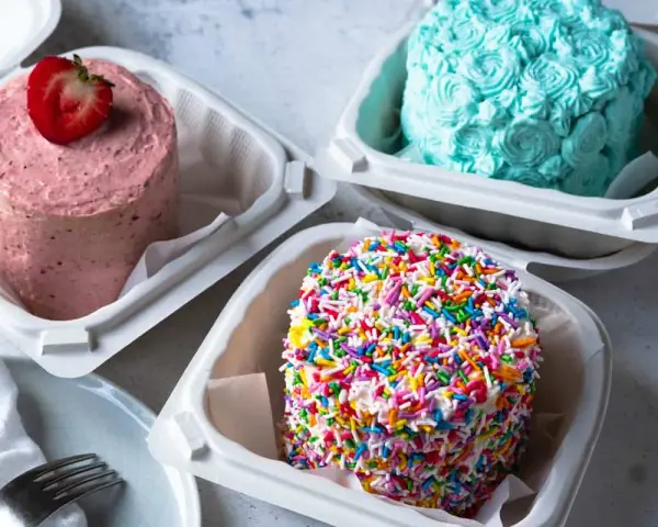 Bento Cake przepis: różowy z truskawką, kolorowy z posypką i turkusowy z dekoracją z kremu. Idealne na małe świętowanie.