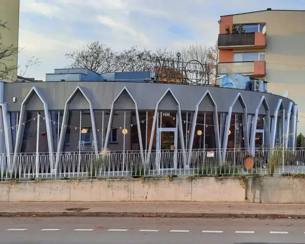 Charakterystyczna modernistyczna architektura budynku z przeszkloną fasadą i geometrycznymi elementami.