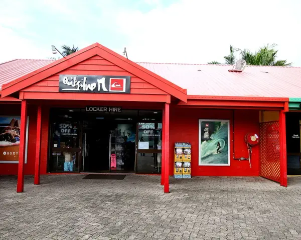 Sklep Quiksilver, znanej firmy odzieżowej dla surferów, z czerwonym logo i ofertą "Locker Hire".