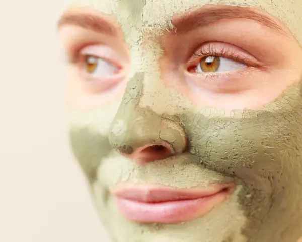 Primo piano di un viso con maschera all'argilla verde. Scopri a cosa serve l'argilla verde per la tua pelle.