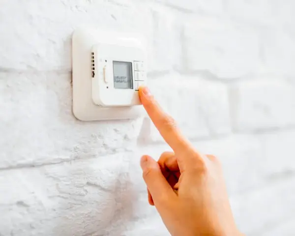 Ajustando el termostato para unos agradables grados calefaccion invierno.