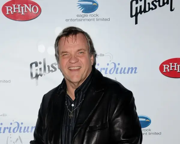 Meat Loaf lächelt in die Kamera, bereit, alles für die Liebe zu tun. Hinter ihm sind Logos von Rhino, Gibson und Eagle Rock Entertainment zu sehen.