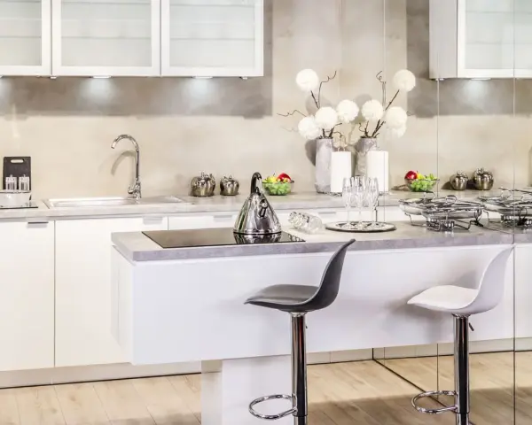 Nowoczesna kuchnia w stylu glamour: inspiracje dla eleganckiego wnętrza. Białe meble, chromowane dodatki i subtelne dekoracje tworzą luksusową atmosferę.