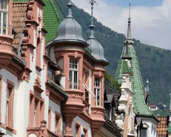 Edifici storici con tetti verdi e torrette a Bolzano, un assaggio di **Bolzano in un giorno**.