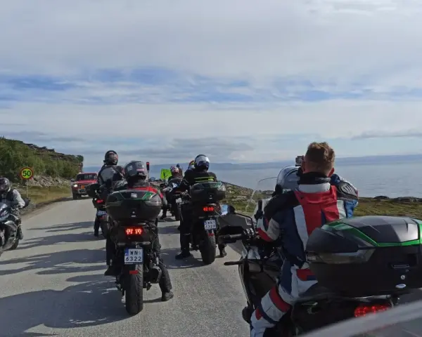 Motocykliści jadący w kierunku Nordkapp w Norwegii, podziwiając malownicze krajobrazy wybrzeża.