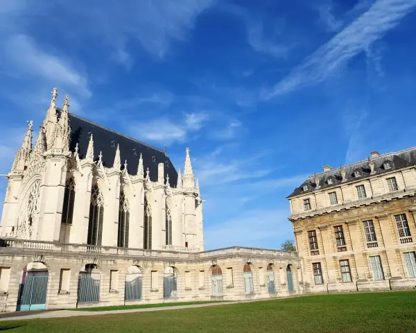 El castillo de Vincennes, con su imponente arquitectura gótica y clásica, se alza bajo un cielo azul vibrante.