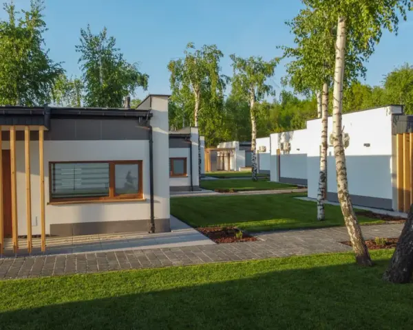 Nowoczesne domki na riviera camp otoczone zielenią i drzewami.