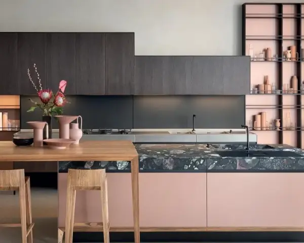 Cucina moderna con isola rosa cipria e piano in pietra scura, pensili in legno scuro. Ottimi abbinamenti colori cucine moderne.