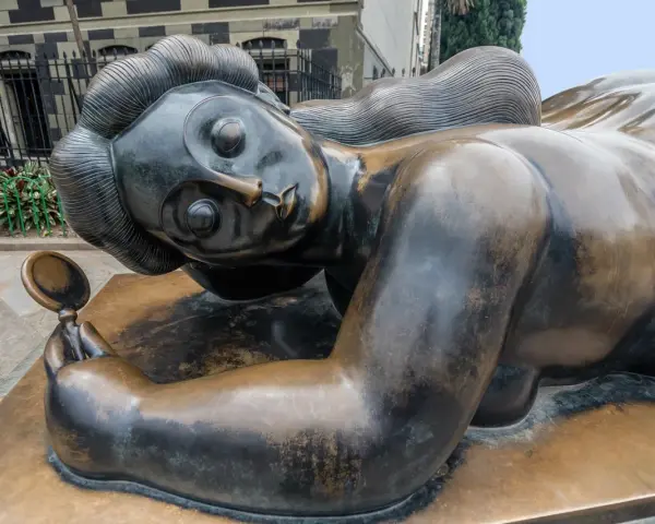 Sculpture d'une femme en bronze, tenant un miroir, évoquant les sculpteurs français contemporains connus.