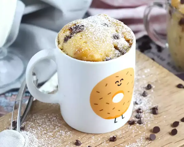 Delicioso bizcocho a la taza con chispas de chocolate, espolvoreado con azúcar glas. ¡Perfecto para un antojo rápido!