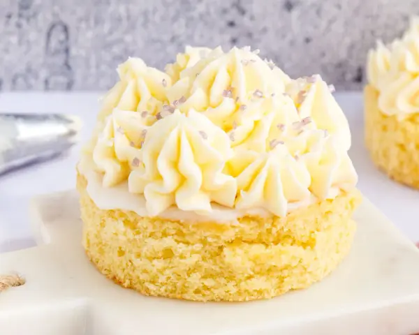 Kleiner Kuchen mit Buttercreme ohne Pudding, verziert mit lila Zuckerstreuseln.