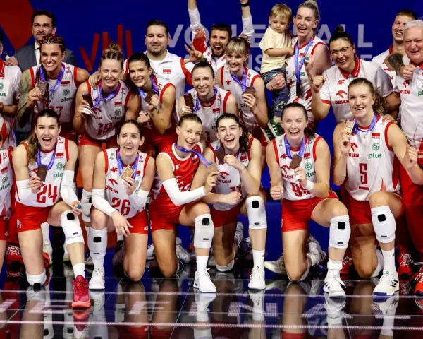 Drużyna siatkówki kobiet Polska świętuje sukces w Lidze Narodów. Zawodniczki z medalami na szyjach i uśmiechami na twarzach.
